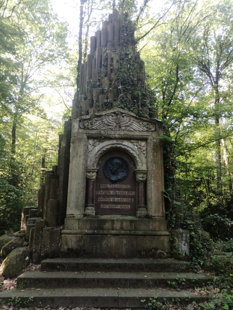 Bonn – Gesamtansicht des Kaiser-Wilhelm-Denkmals auf dem Venusberg, gestaltet im neuromanischen Stil aus Sandstein und Granit, umgeben von Natur.