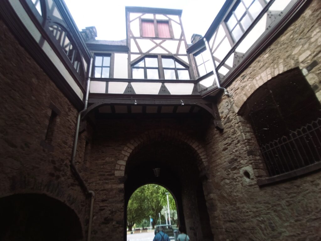 Innenansicht des Rheintors in Andernach mit Blick auf das Fachwerkhaus und den Torbogen.