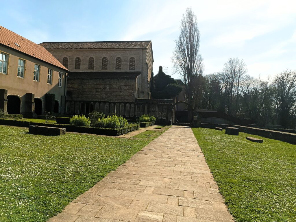 Historische Außenansicht von Saint Pierre aux Nonnains in Metz, mit einem Weg, der durch den Garten führt.