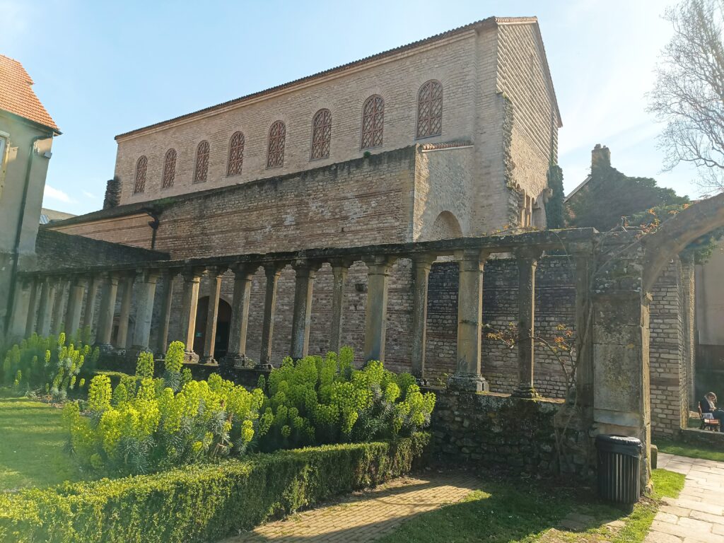 Historische Kirche Saint-Pierre-aux-Nonnains mit Arkaden im Vordergrund und Hauptfassade bei Sonnenlicht.