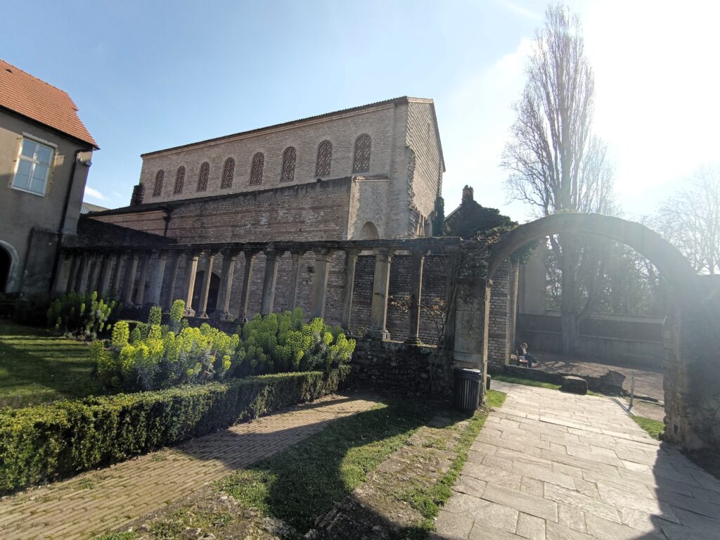 Historische Kirche Saint-Pierre-aux-Nonnains mit Arkaden im Vordergrund und Hauptfassade bei Sonnenlicht.