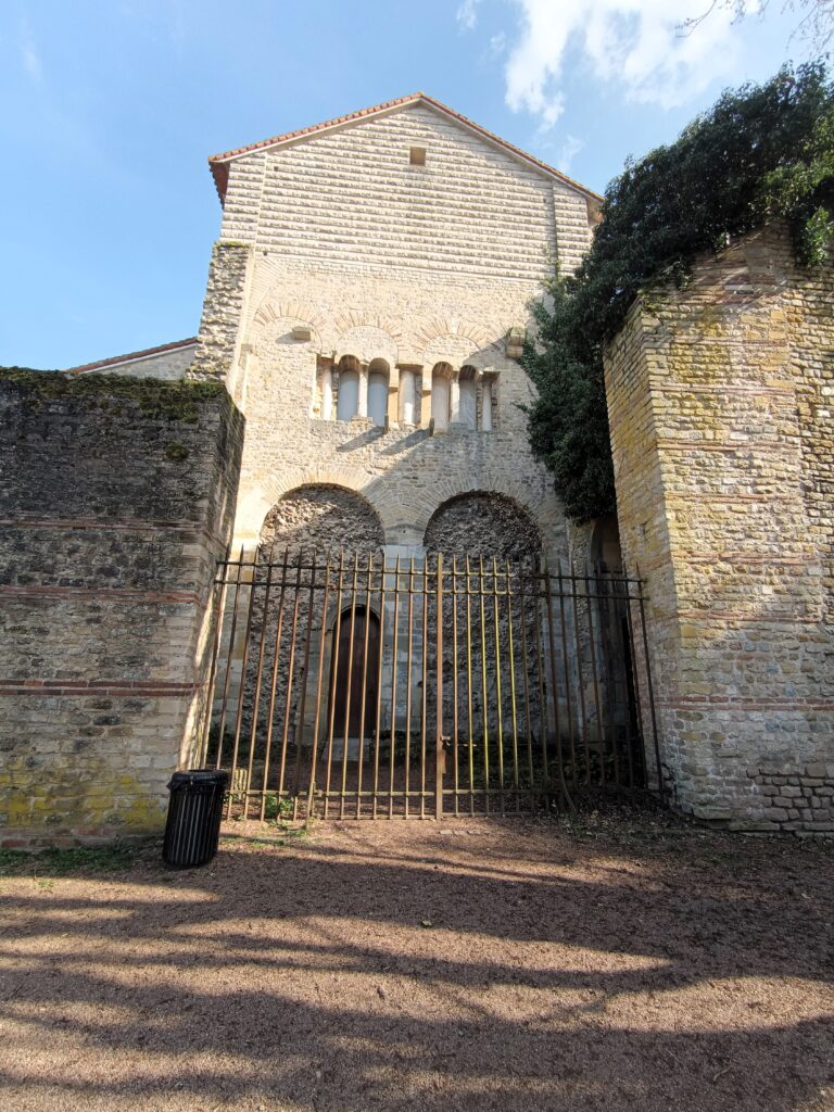 Gesamtansicht der Westfassade von Saint-Pierre-aux-Nonnains mit Bögen und Schutzgitter.