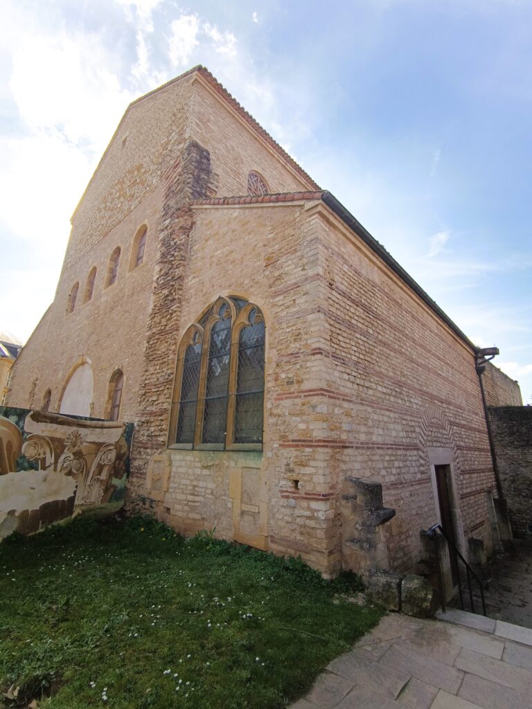 Südseite der Kirche Saint-Pierre-aux-Nonnains in Metz mit gotischen Fenstern, Rundfenster und romanischer Mauerstruktur.