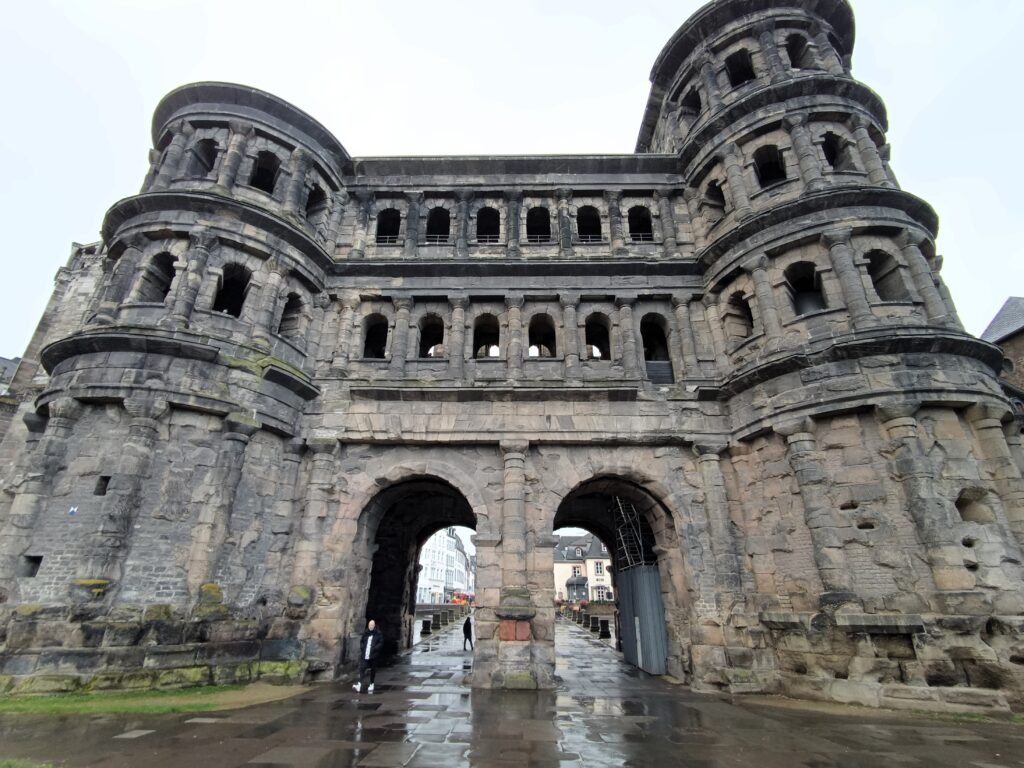 Porta Nigra in Trier, Außenansicht bei Tageslicht mit klar sichtbaren römischen Architekturelementen und massiven Türmen.