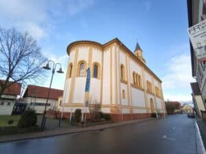Sakralbau in Deutschland 18 Außenansicht der katholischen Pfarrkirche St. Martin in Lingenfeld, neoromanischer Saalbau mit Rundapsis und Turm.