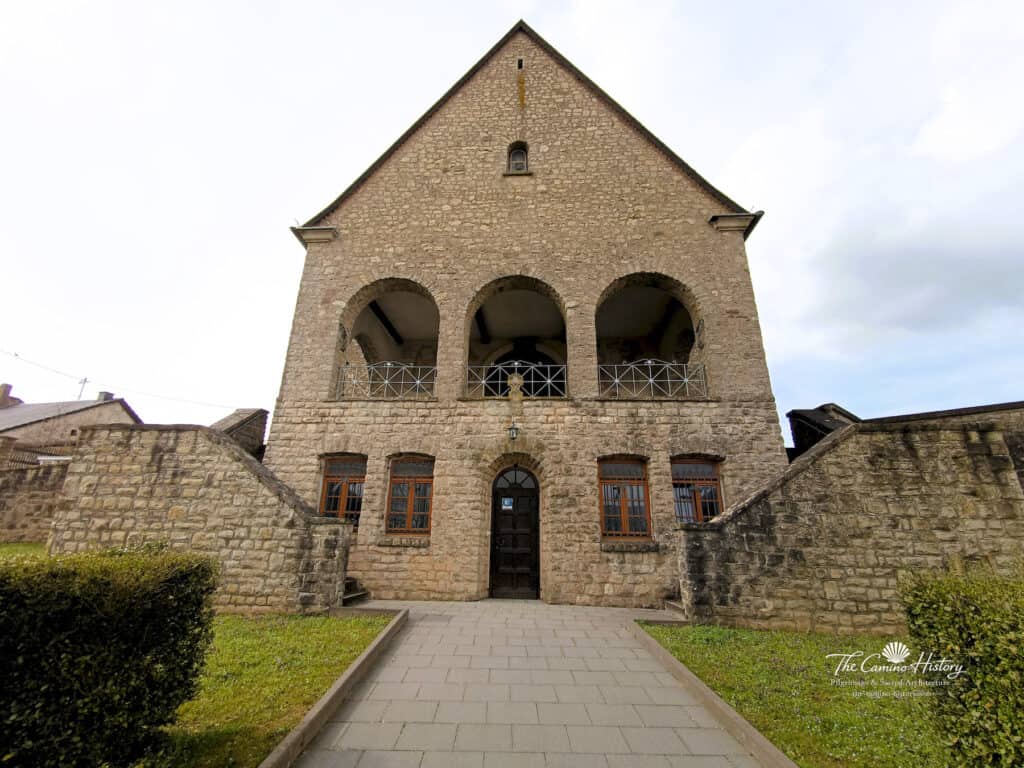 Fassade der Pfarrkirche St. Johannes der Täufer in Borg, Steinbau mit symmetrischen Bögen und einer zentralen Tür
