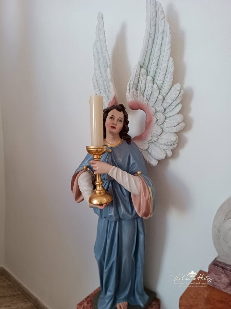Engelsfigur im blauen Gewand mit vergoldetem Kerzenleuchter in St. Bartholomäus Fischbach bei DahnFarbig gefasster Leuchterengel mit großen weißen Flügeln und einem vergoldeten Kerzenhalter.