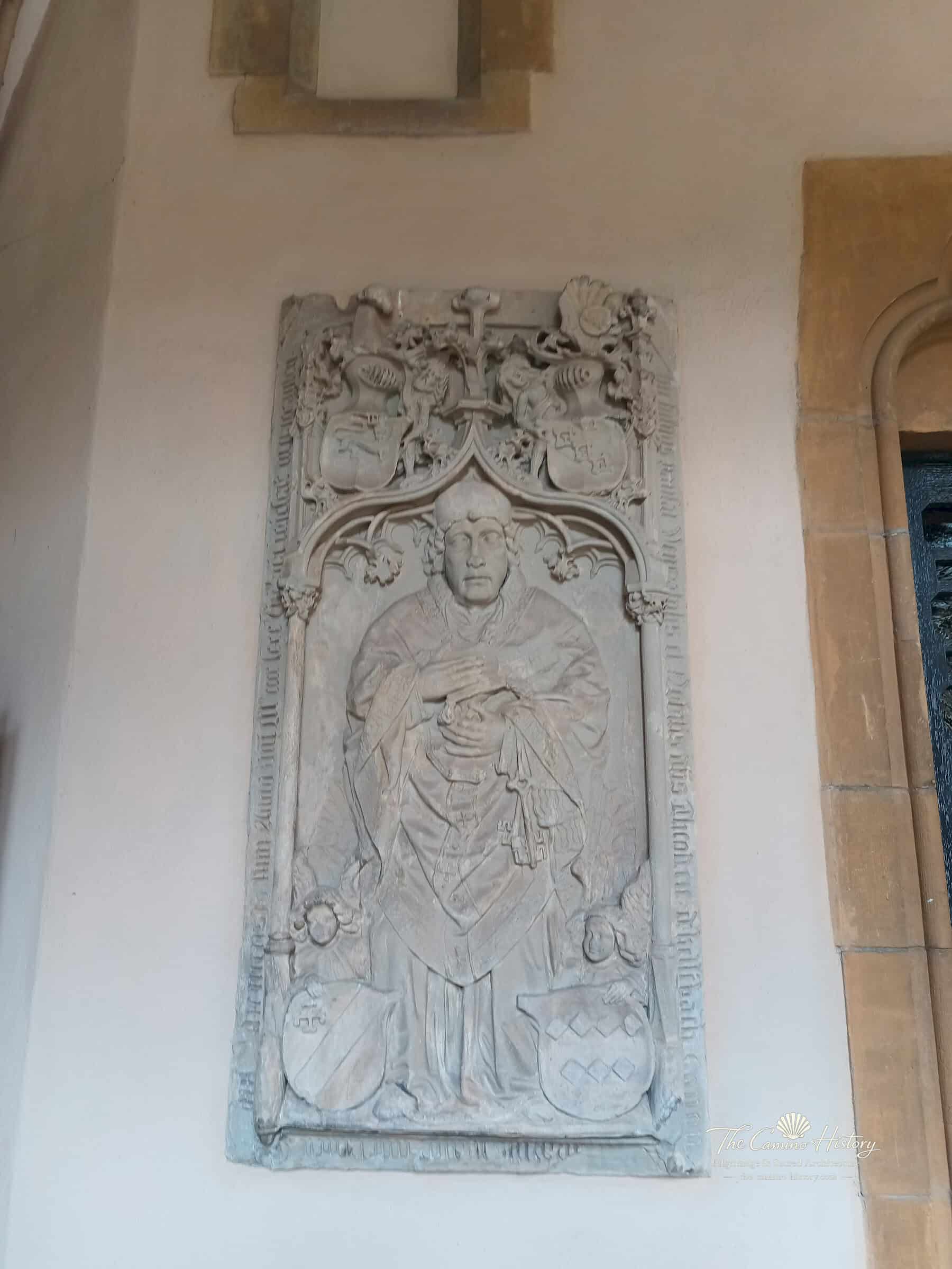 Spätgotische Wandgrabplatte des Domschatzmeisters Theoderich von Kellenbach im Trierer Domkreuzgang: figürlicher Geistlicher, vier Wappenschilde und Randinschrift