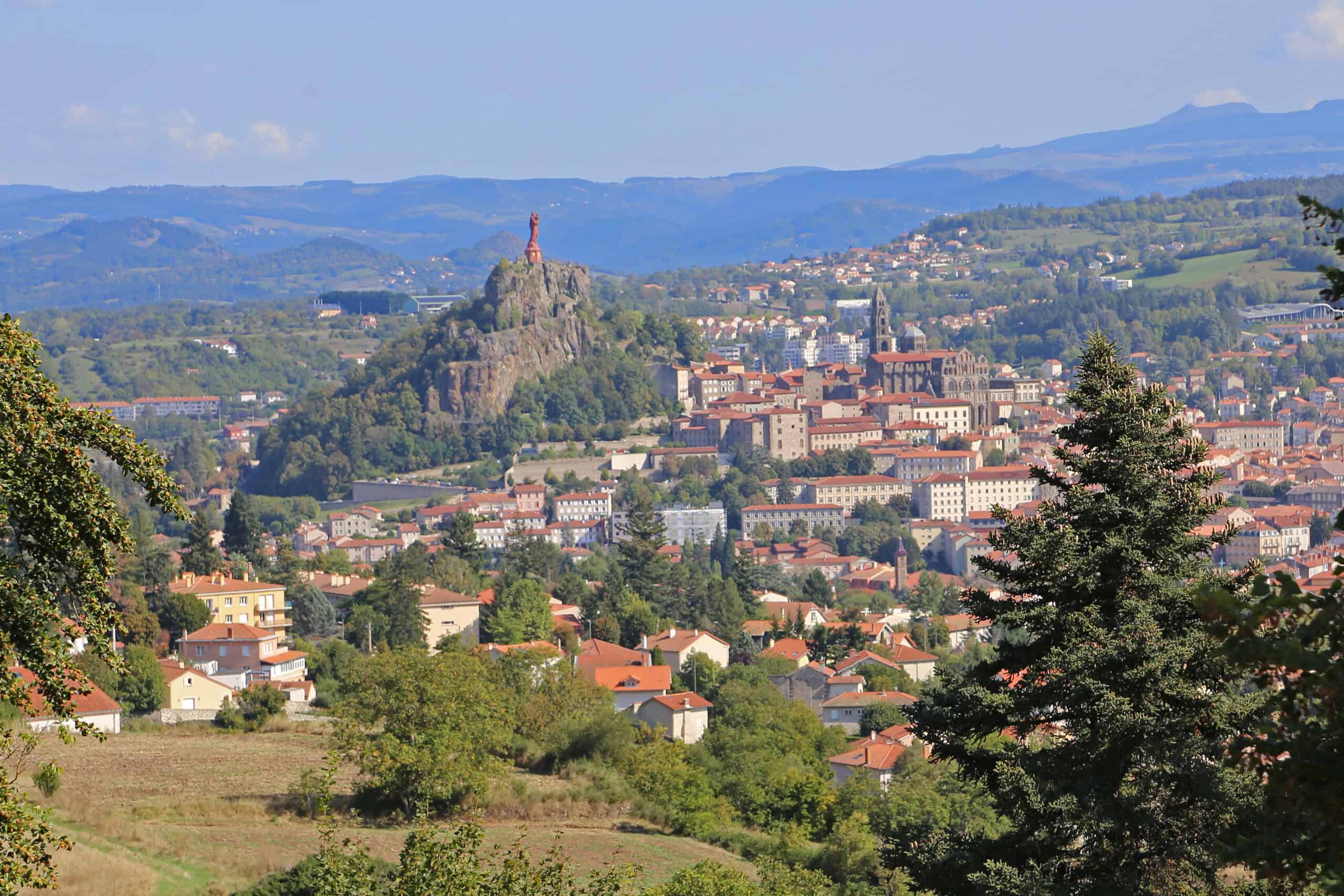 Panoramablick auf Le Puy-en-Velay mit der Statue Notre-Dame de France auf dem Felsen Rocher Corneille