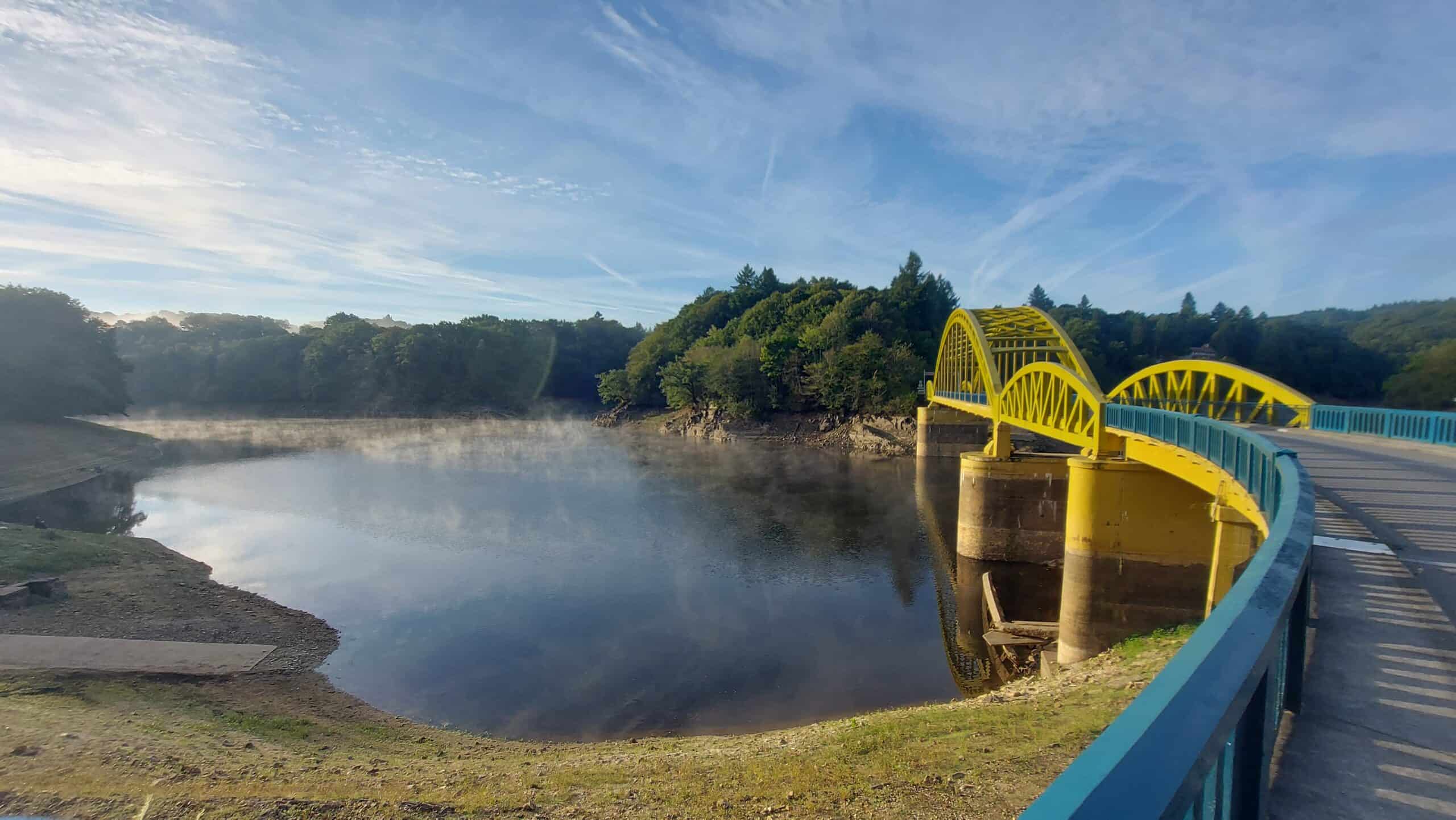 Gelbe Bogenbrücke über einem ruhigen Gewässer