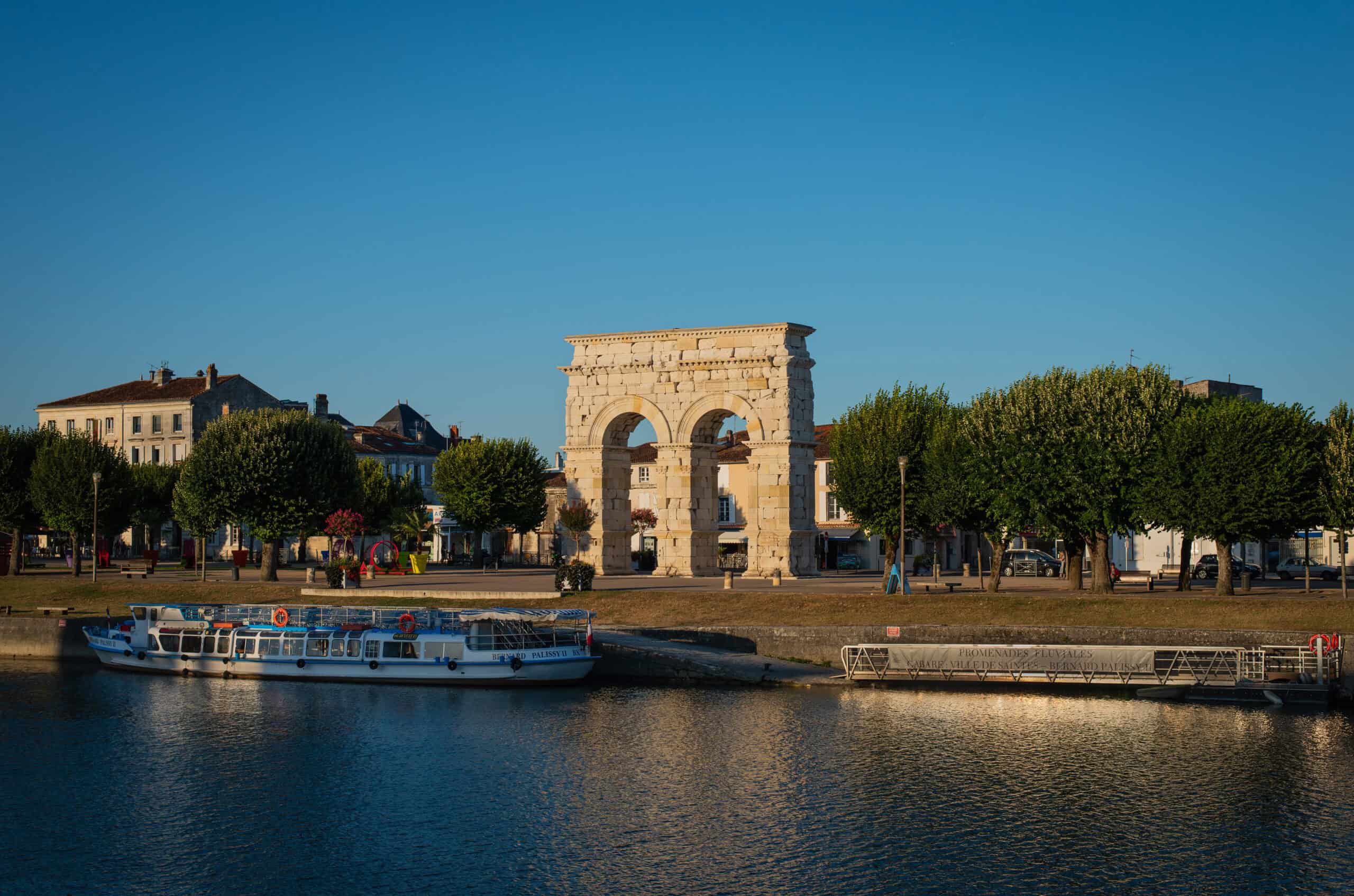 via turonensis 8 Römischer Bogen Arc de Germanicus am Ufer der Charente in Saintes mit Boot auf dem Fluss