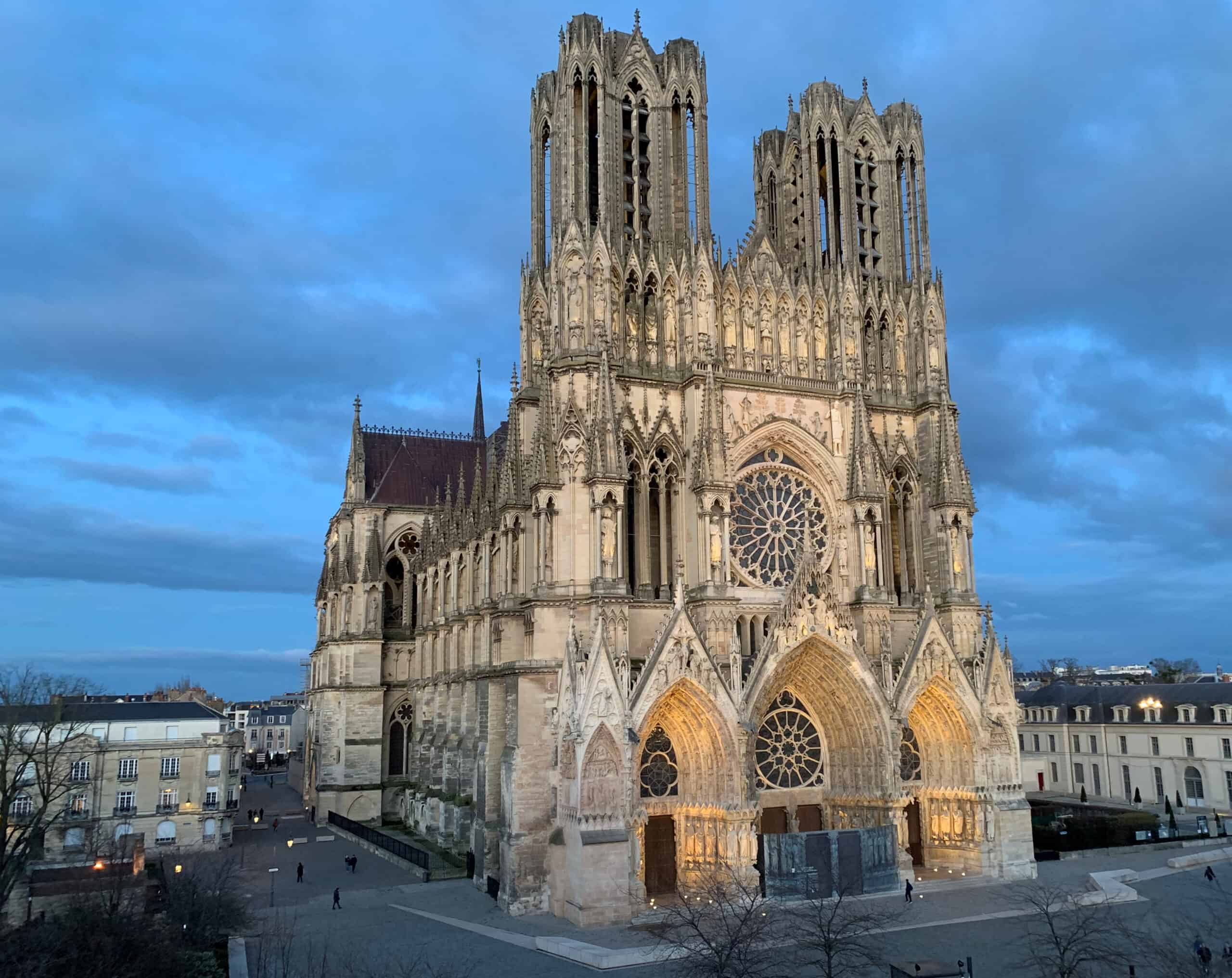 Westfassade der gotischen Kathedrale Notre-Dame in Reims mit zwei Türmen im Abendlicht