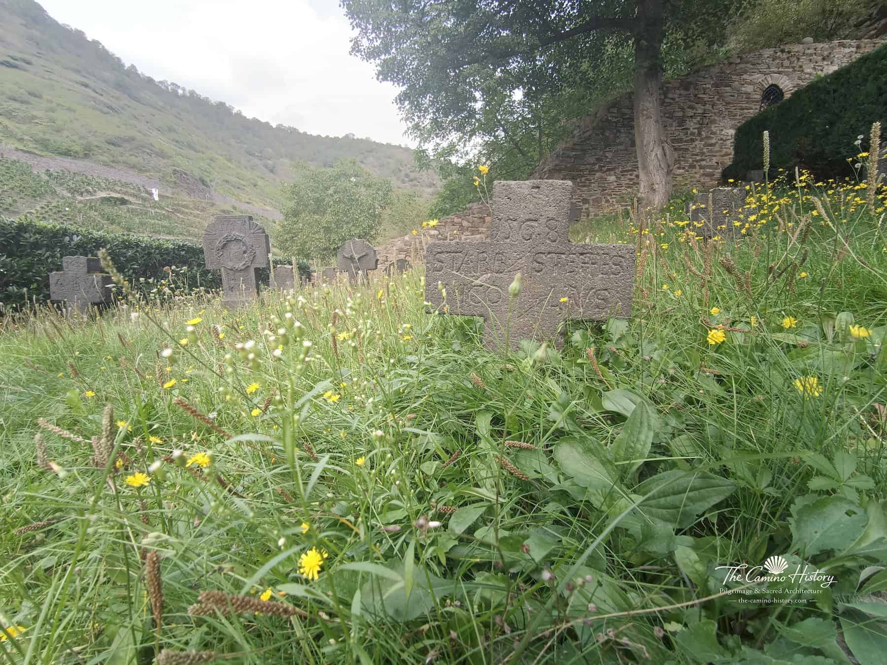 Verwitterte Basaltgrabkreuze im Gras am alten Kirchhof von St. Michael in Alken