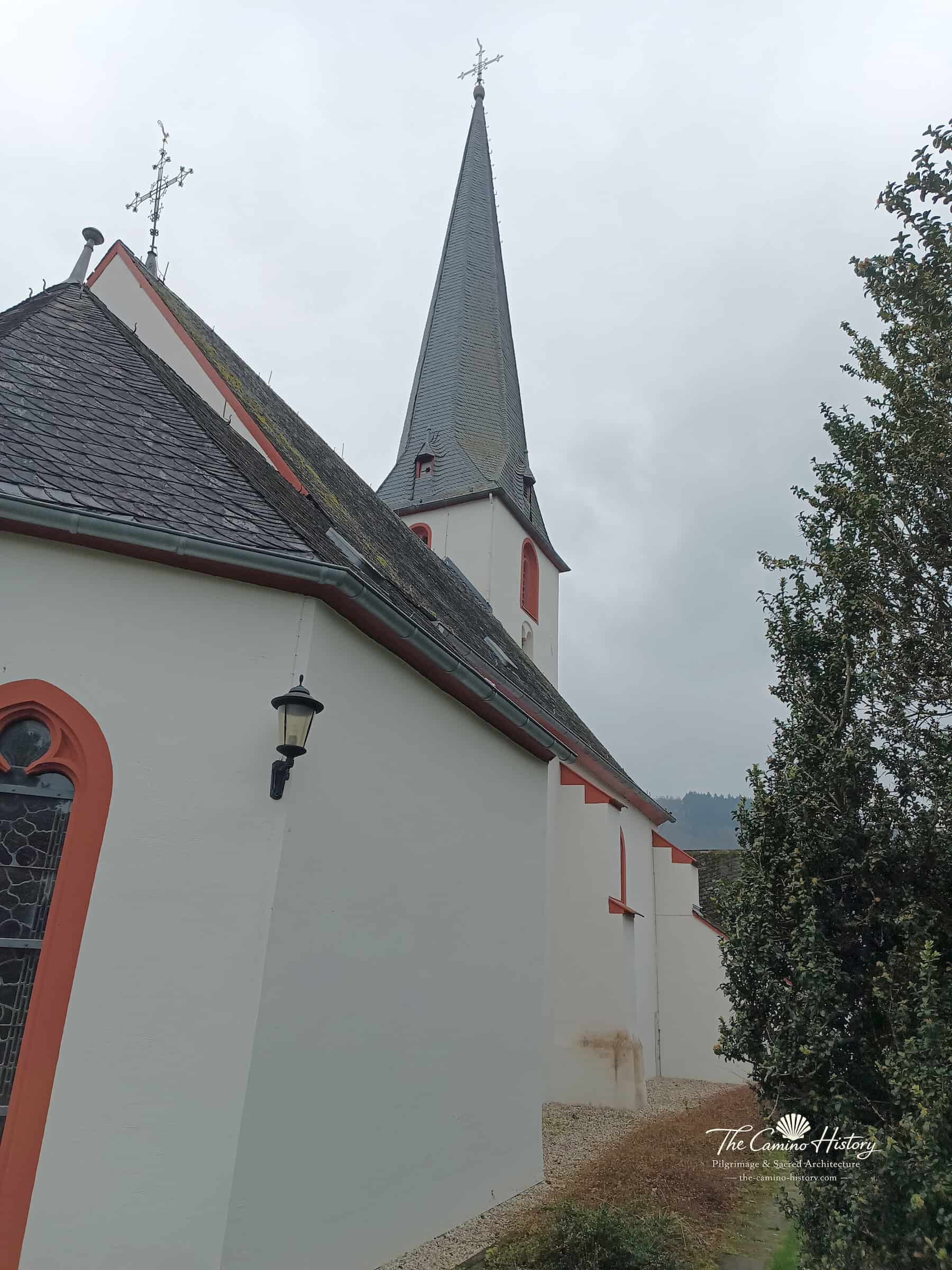 Seitenansicht der evangelischen Peterskirche in Traben mit schlankem Schieferhelm und gotischem Fenster