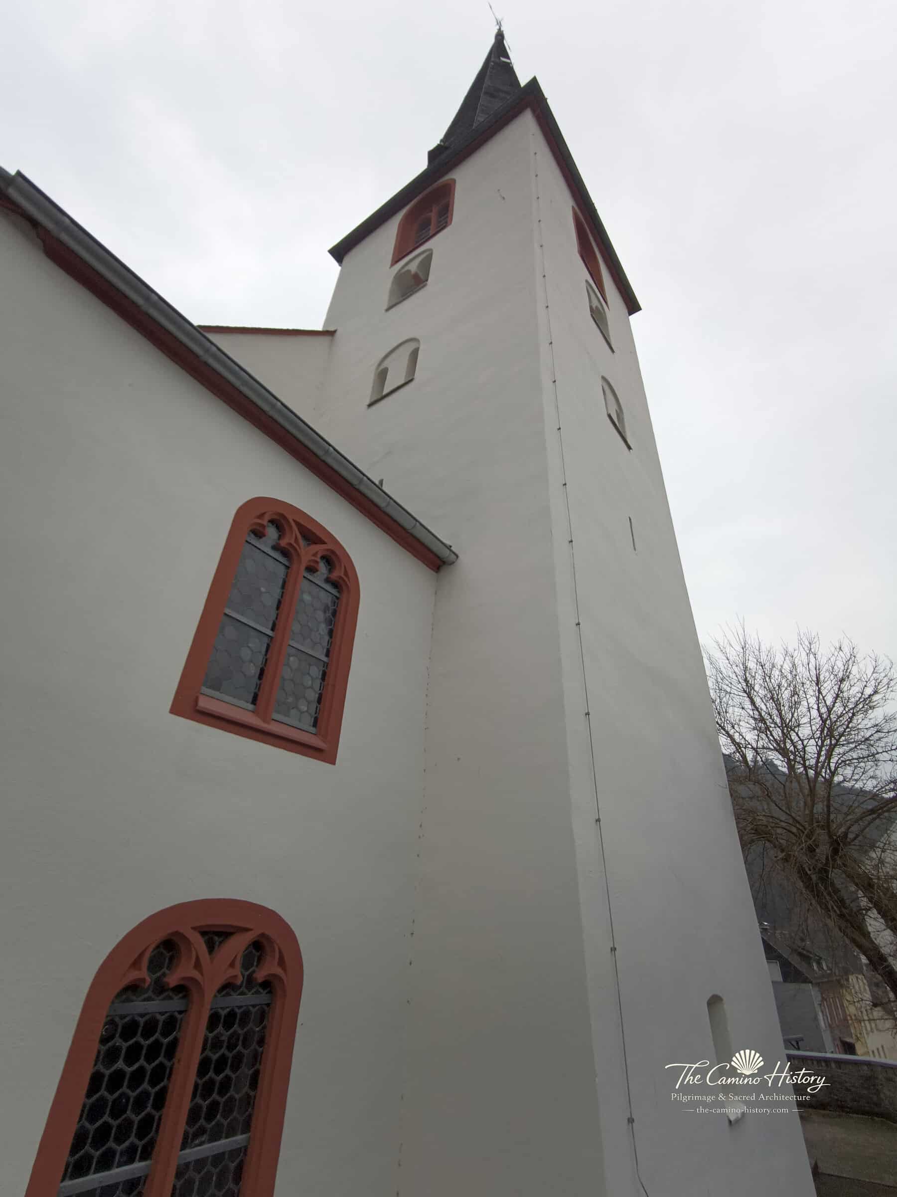 Nahaufnahme des weiß verputzten Kirchturms der Peterskirche in Traben mit romanischen Schallöffnungen und gotischem Spitzbogenfenster