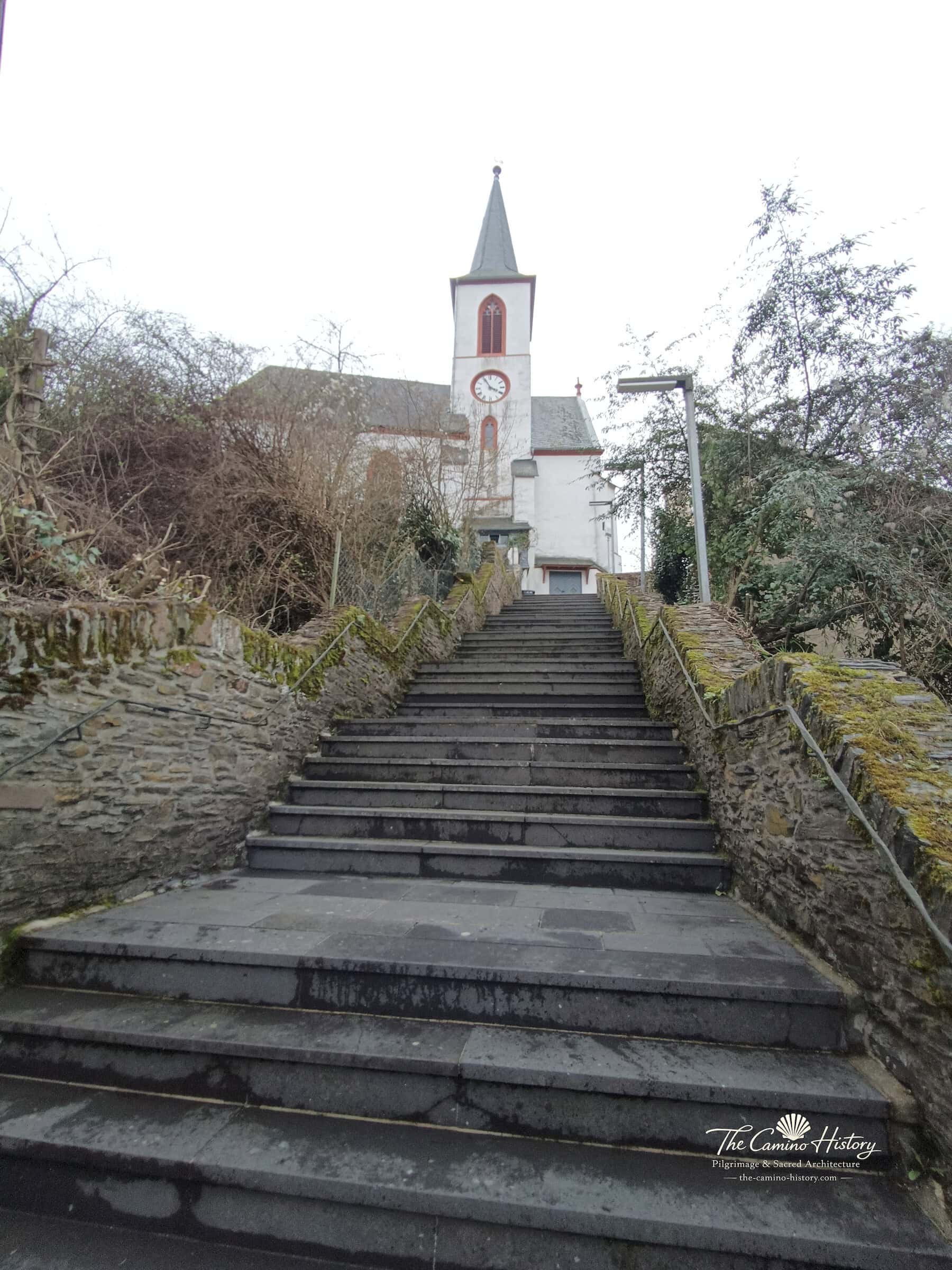 Trarbach – Evangelische Kirche (ehemals St. Nikolaus) 3 Blick vom unteren Treppenabsatz über die lange Steintreppe hinauf zur evangelischen Kirche Trarbach mit Turmuhr