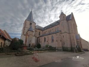 Pfälzer Jakobsweg Südroute 10 St. Georg in Landau-Arzheim. Der heutige neuromanische Kirchenbau entstand 1902–1904; der ältere spätgotische Chorturm der Vorgängerkirche blieb erhalten.