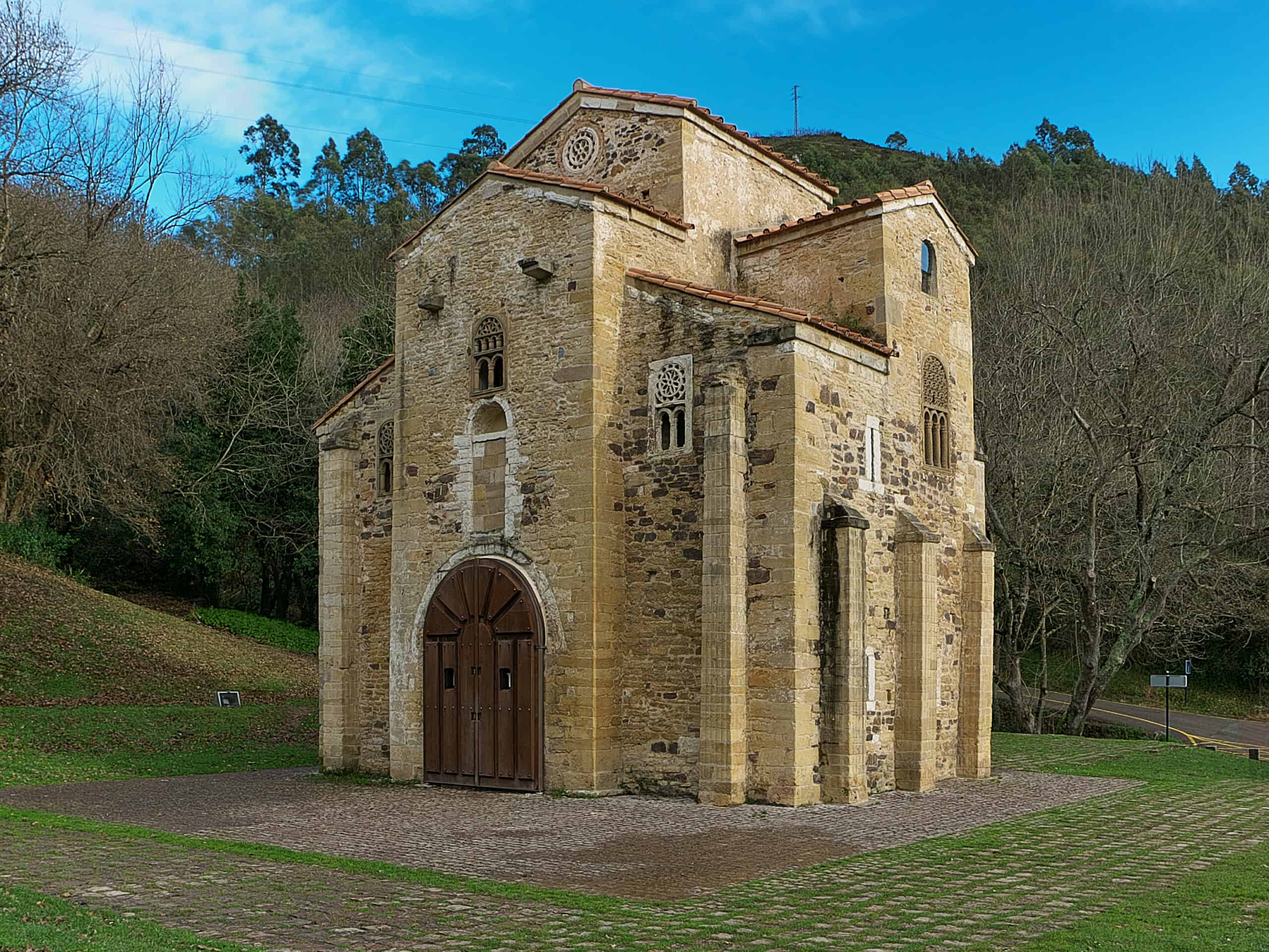 Romanische Kirche San Miguel de Lillo in Oviedo vor grünem Hang