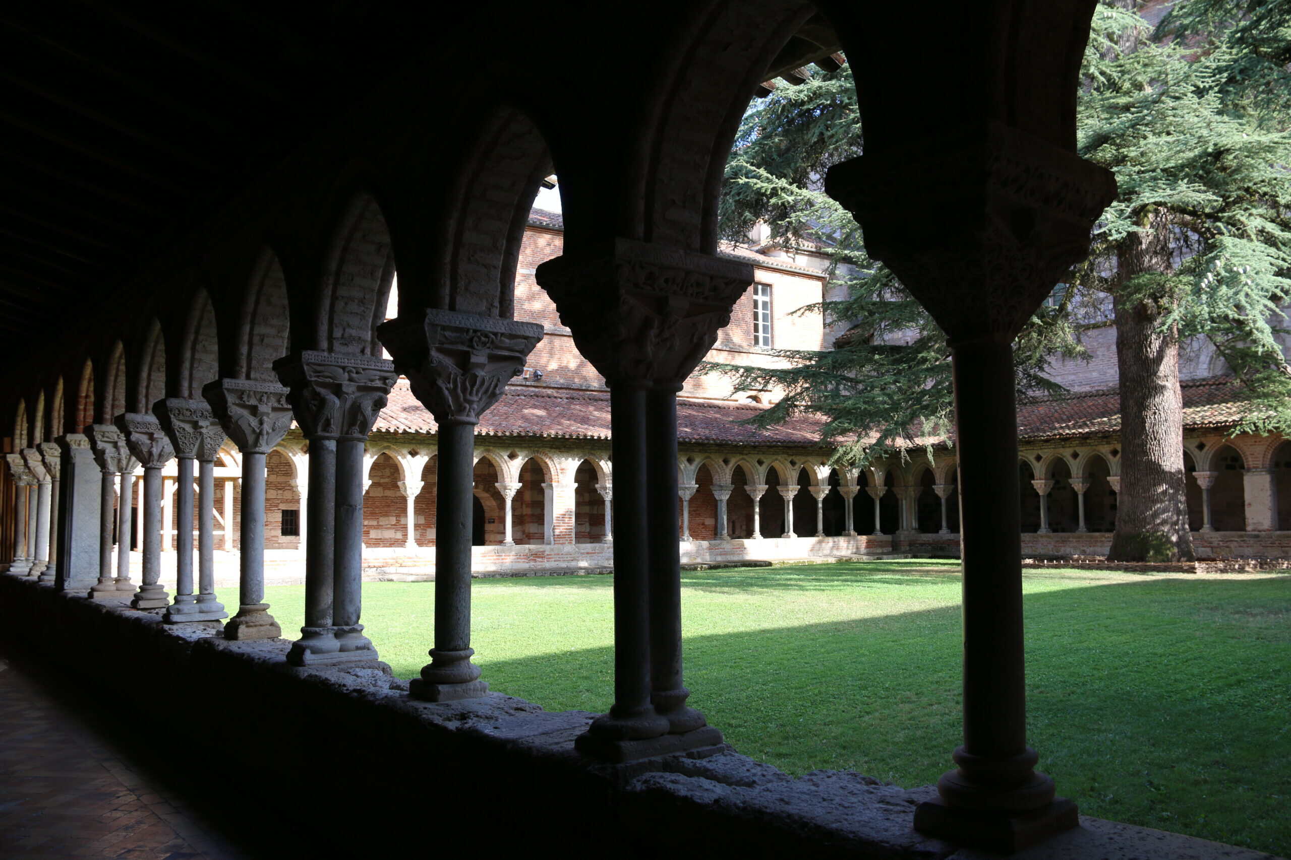 Romanischer Kreuzgang der Abtei Saint-Pierre in Moissac mit Säulen, Arkaden und begrüntem Innenhof