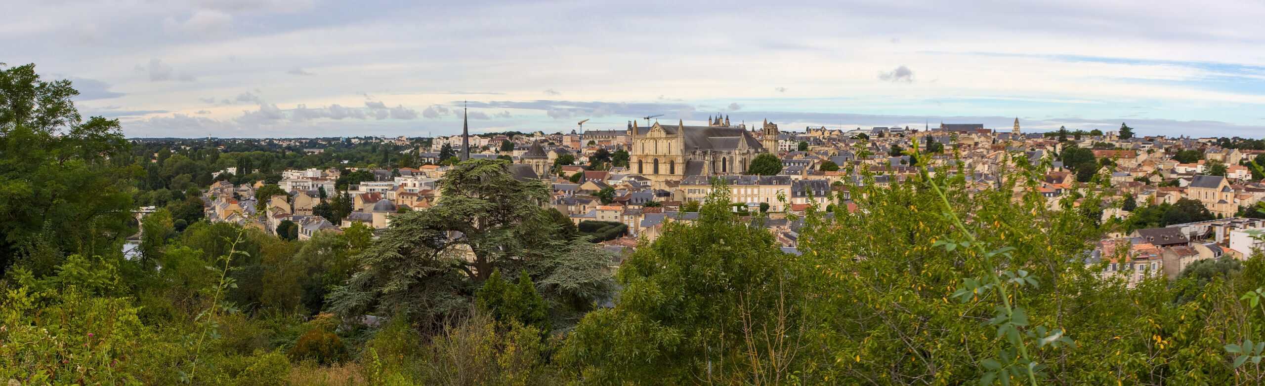 via turonensis 5 Weites Panorama von Poitiers mit zahlreichen Kirchendächern und historischen Gebäuden, gesehen von einem begrünten Aussichtspunkt